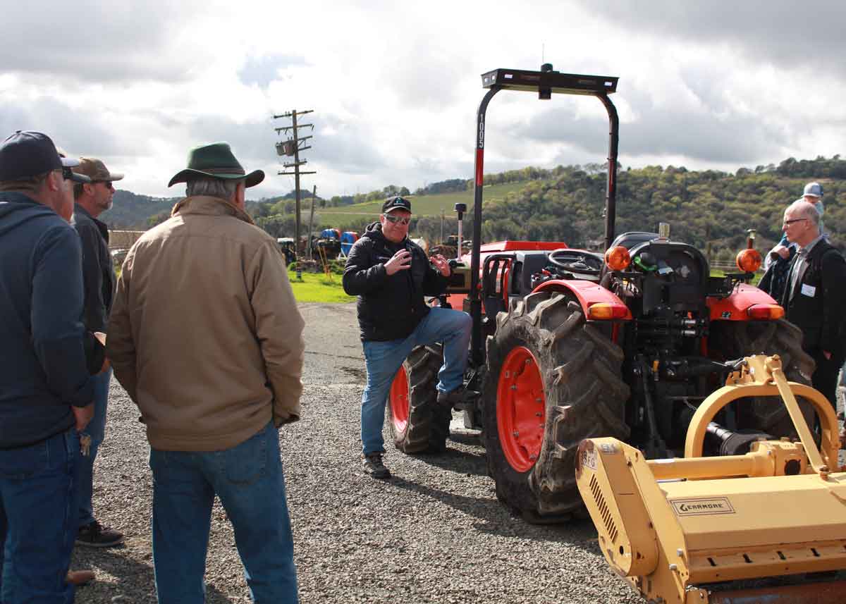 Tim Bucher CEO of Agtonomy demonstrates autonomous specialty crop ag tech tractor to growers outdoors