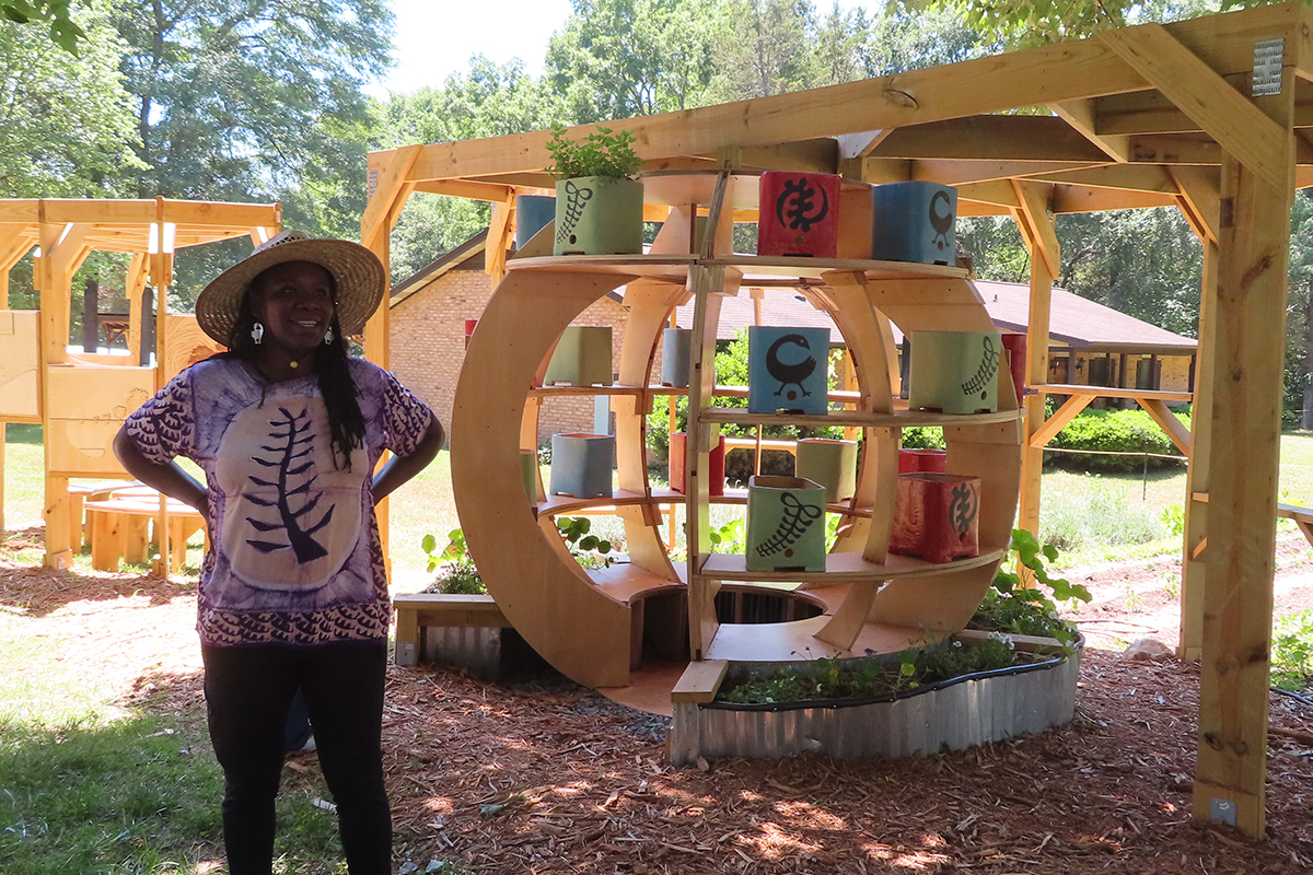 Deep Roots CPS Farm co-founder Cherie Jzar stands beside the farm's architectural ecodome.