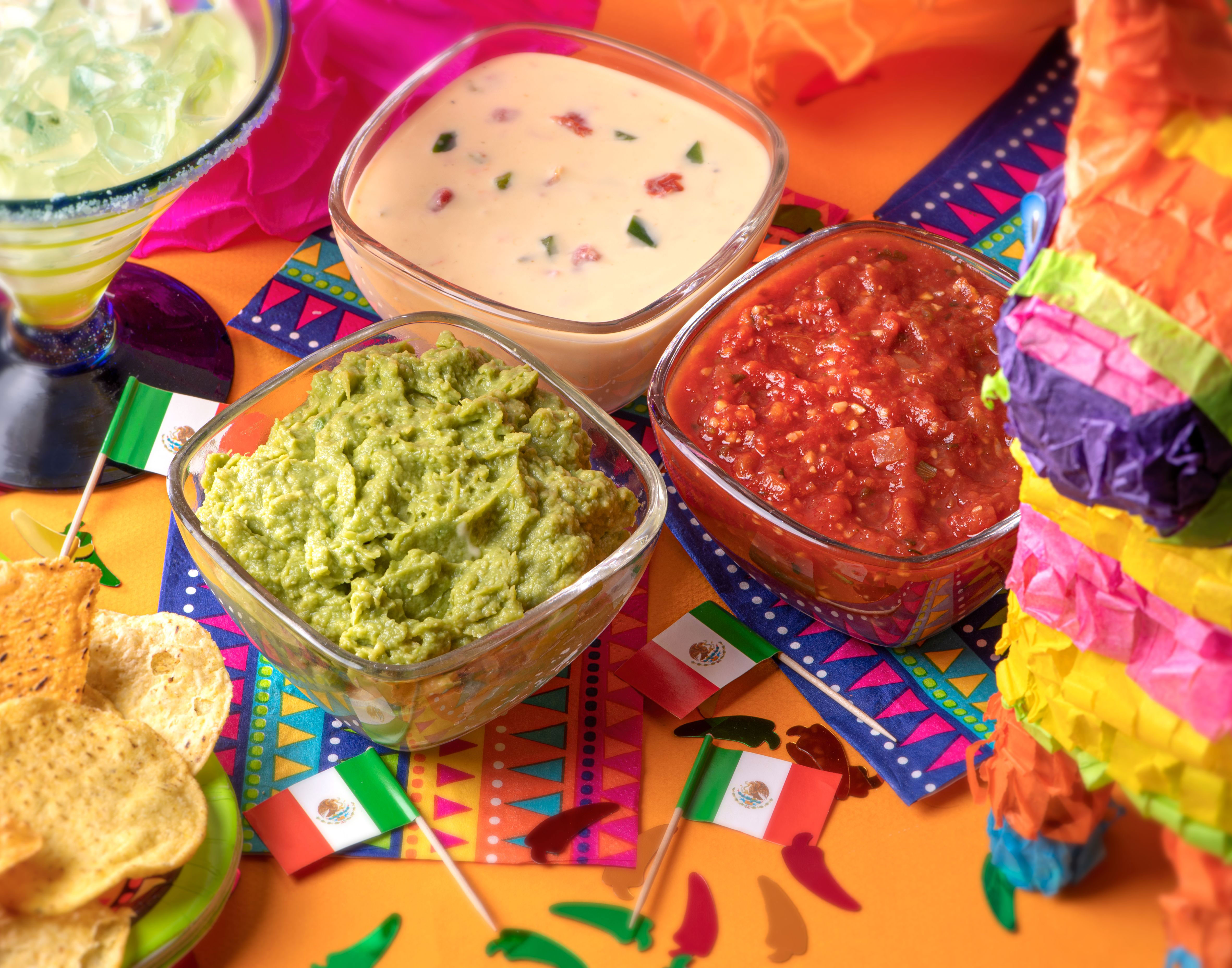 Cinco de Mayo food setup with guacamole, queso dip and salsa
