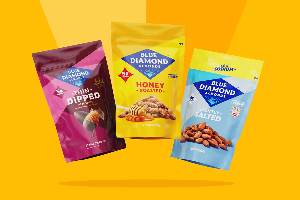 Colorful packs of Blue Diamond almonds—Thin Dipped, Honey Roasted, and Lightly Salted—are displayed against a vibrant yellow backdrop_.png