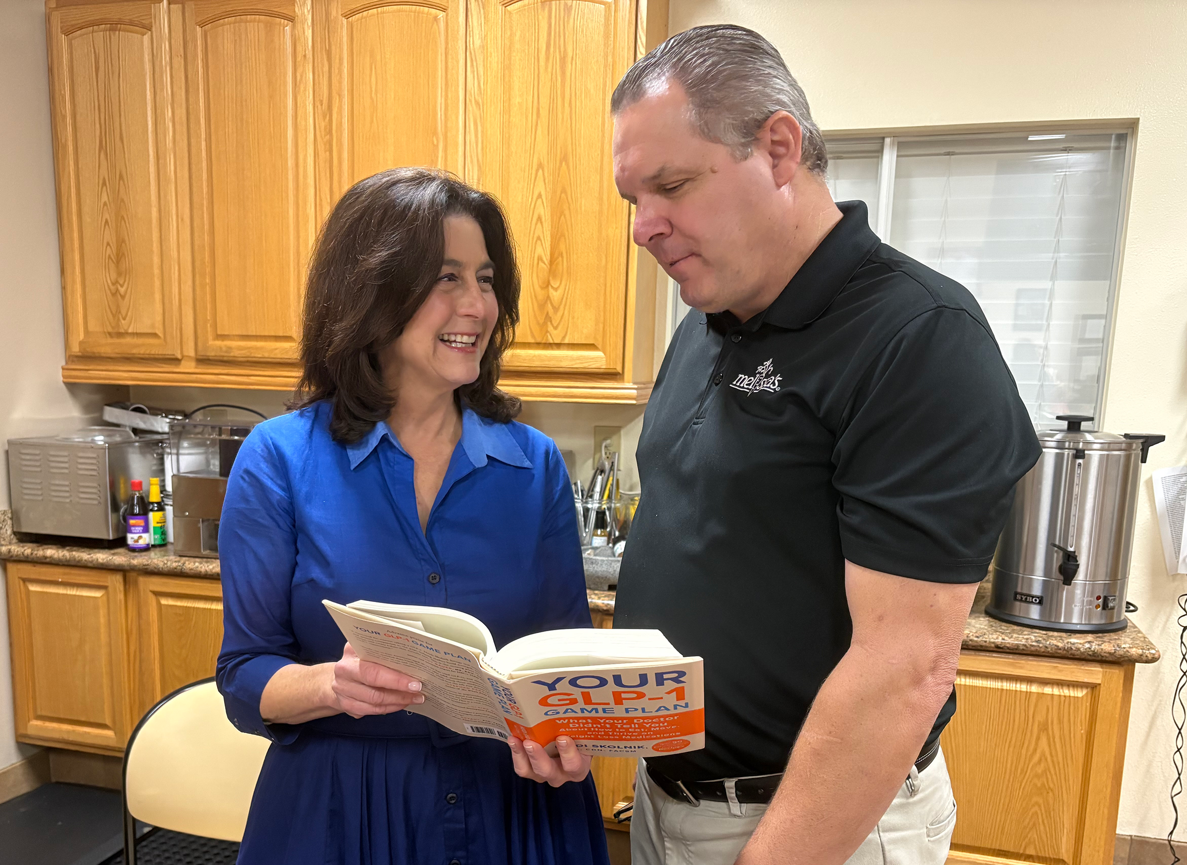 Sports nutritionist Heidi Skolnik and Robert Schueller, director of public relations, check out Skolnik's new book during a media event at the Melissa's Produce test kitchen in Los Angeles.
