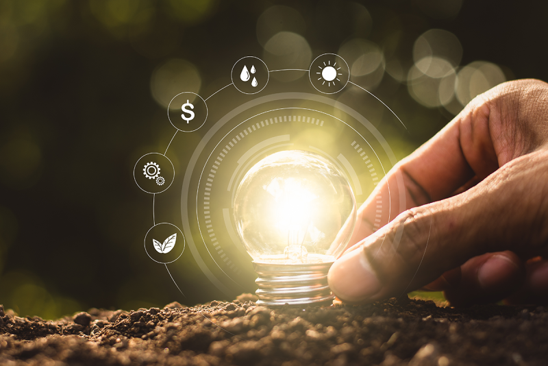 agtech photo illustration of hand placing light bulb in soil