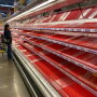 An empty grocery store meat case in March.