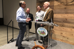 Industry professionals talk after a speaking event at the 2019 New England Produce Council Expo.
