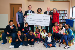 USApple president and CEO Jim Bair (top row, second from left) presents a 2019 Apples4Ed grant award to Baltimore’s Robert W. Coleman Elementary. USApple board member Ryan Hess (top row, left) of Hess Brothers Fruit Co. in Pennsylvania provided apples for the student body.