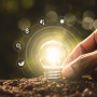 agtech photo illustration of hand placing light bulb in soil