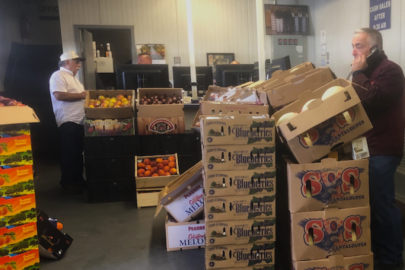 Peter Resteghini (right), buys and sells mostly berries and melons for 4M Fruit Distributors at the New England Produce Center.