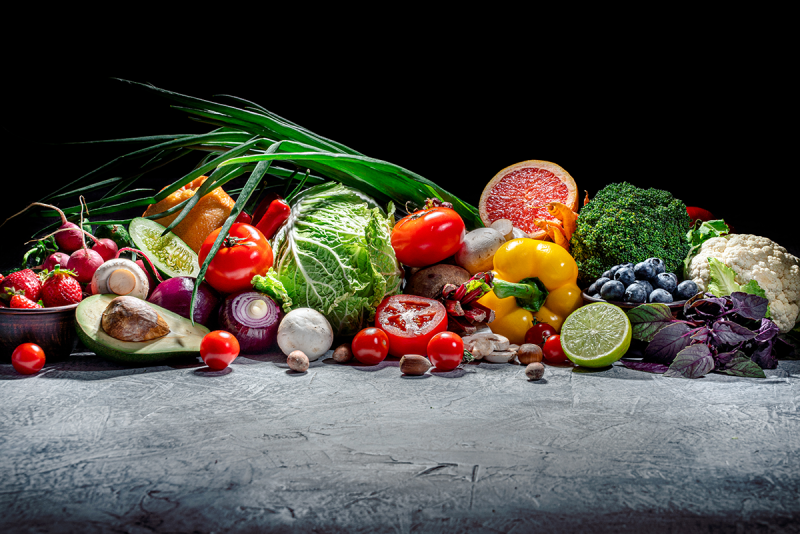 A pile of dramatically-lit fresh fruits and vegetables