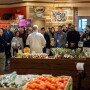 A group of program participants listens to a speaker during a produce retail tour.