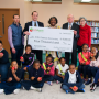 USApple president and CEO Jim Bair (top row, second from left) presents a 2019 Apples4Ed grant award to Baltimore’s Robert W. Coleman Elementary. USApple board member Ryan Hess (top row, left) of Hess Brothers Fruit Co. in Pennsylvania provided apples for the student body.