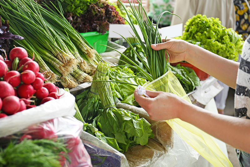 Shopper examining vegetables on a display