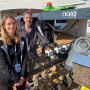 Ingrid Sarlandi and ??? of Naio Technologies stand next to Orio, a top ten product winner at the World Ag Expo this year. Orio is a straddle robot designed for row crops and beds of vegetables. 