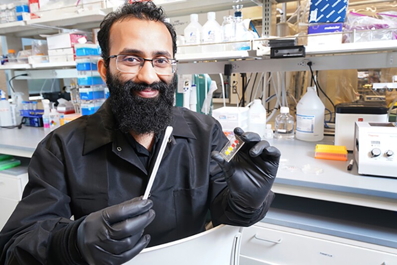 Mohit Verma, professor of agricultural and biological engineering in Purdue University’s College of Agriculture, holds a prototype for a low-cost test to diagnose COVID-19 in animals.