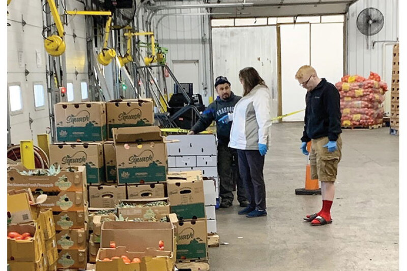 Holthouse Farms staff and others check out supplies for orders placed online with the company during the COVID-19 pandemic.