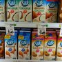 Shot of grocery store cooler loaded with various "Silk" brand of plant-based milk-like products, almond, coconut, cashew, almond