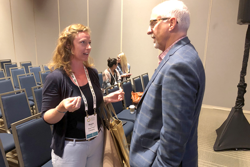 At another conference, Steve Lutz (right) speaks with an attendee after a session.