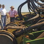 Farmers chatting near equipment.