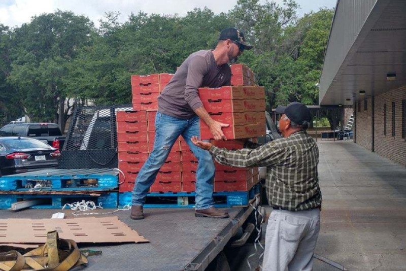 The USDA's plan is designed to find charitable outlets for fresh fruits and vegetables, dairy and meat. In this file photo, Chris Parks (left), farm manager for Wish Farms, helps unload pallets of strawberries at one donation to food banks in the Plant City, Fla., area.