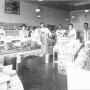 An early 20th century black and white photo of grocery store with clerks