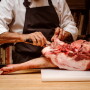 Adam Kaye, vice president of culinary affairs, butchers a Berkshire pork leg at the Blue Hill restaurant.
