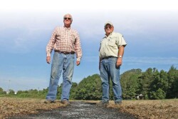 Standing over a burned windrow, Harry Stephens, left, and Robert Goodson hope the payoff is a direct assault on the mother lode source of weed seed.