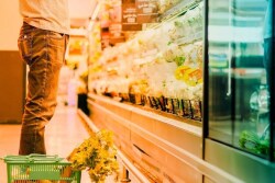 headless guy at supermarket with basket of produce