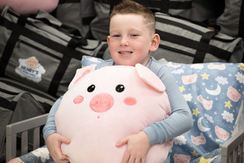 Henry Johnson, the grandson of Deb and Jeff Hansen, holds items from one of the 500 Dream Kits donated to children and family advocacy and intervention centers across Iowa through the Deb and Jeff Hansen Foundation Henry's Heroes program.