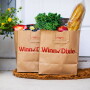 Two bags of groceries sit side by side on a doorstep.