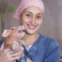 Employee on sow farm holding piglet