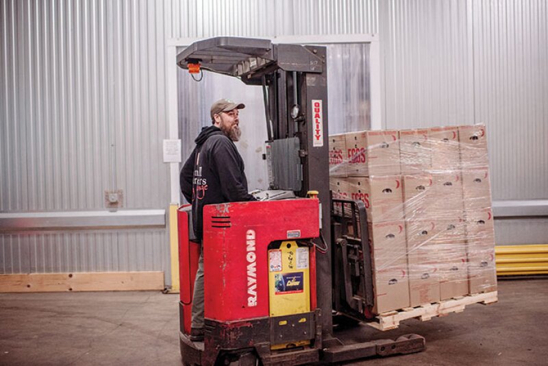 A worker loads product at Co-op Partners Warehouse. Melons, locally grown cucumbers and bell peppers and some late corn will be among the wholesale distributor’s products for late summer, says Tom Rodmyre, warehouse director.