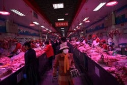 Customer wearing face masks buy pork meat at a wholesale market for agricultural products, as the country is hit by an outbreak of the novel coronavirus, in Beijing, China February 19, 2020. REUTERS/Tingshu Wang