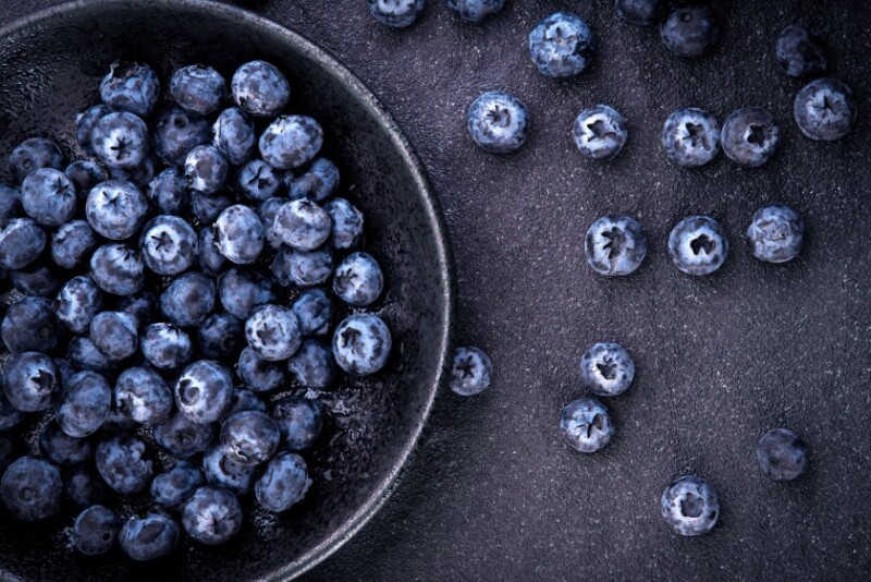 Blueberries in a bowl and on a table