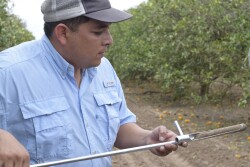 Zach Lopez inspects a soil sample.