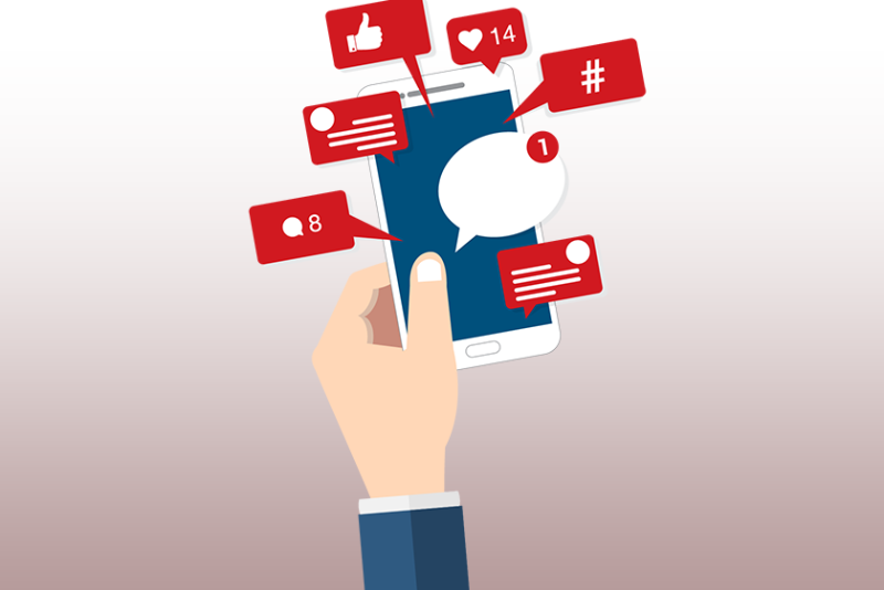 hand holding phone with comment and like bubbles coming out of it