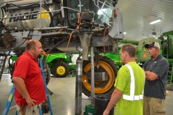 Paul Klein (left, red shirt) and Joe Klein (right, gray shirt) work employees to make sure everyone is understood.