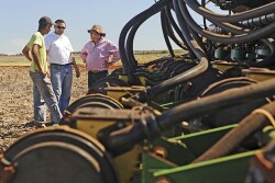 Farmers chatting near equipment.