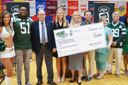 On hand for a $20,000 check presentation to Ocean Township Intermediate School were Jets Flight Crew member Jenna (from left), Jets linebacker Brandon Copeland, New Jersey Secretary of Agriculture Douglas Fisher, Jets community relations assistant Maddy Brown, Ocean Township Schools Sodexo foodservice manager Jackie Wagner, physical education teacher John Dellapesca, NJDA school nutrition programs marketing specialist Jackie Bricker, school principal Larry Kostula, and American Dairy North East marketing representative Aisha King.