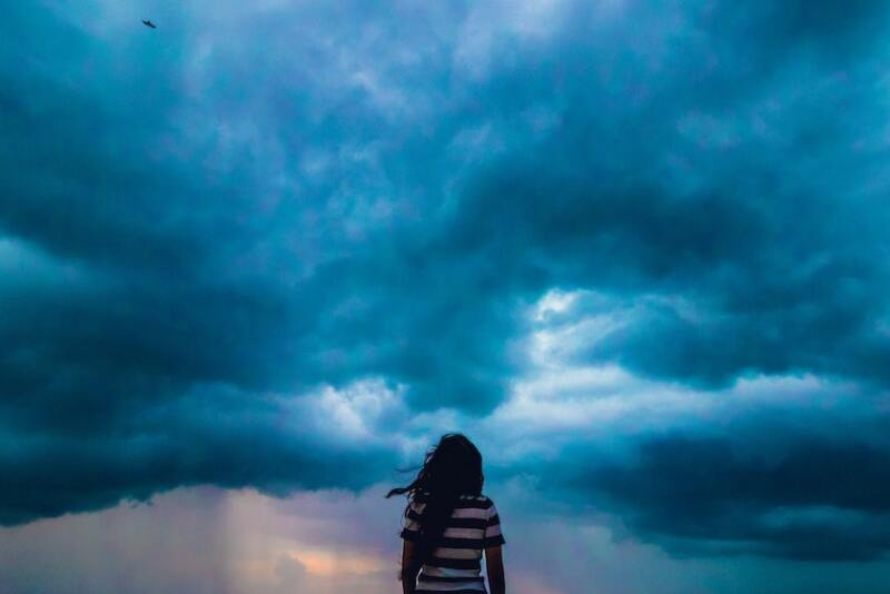 woman looking at stormy sky unsplash shashank sahay