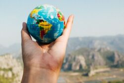Globe in outstretched hand by Canva