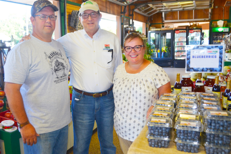 New Jersey Secretary of Agriculture Douglas Fisher (center) visits Russo’s Fruit and Vegetable Farm owners Anthony and Melissa Russo, who have a Jersey Fresh blueberry display in their farm market in Tabernacle.
