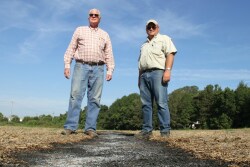 Harry Stephens, left, and Robert Goodson stand over a burned down windrow. The payoff is a direct assault on the motherlode source of weed seed.