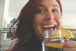 woman holding mason jar of water with lemon wedges in it
