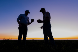 Two men representing the melon shippers standing in a field