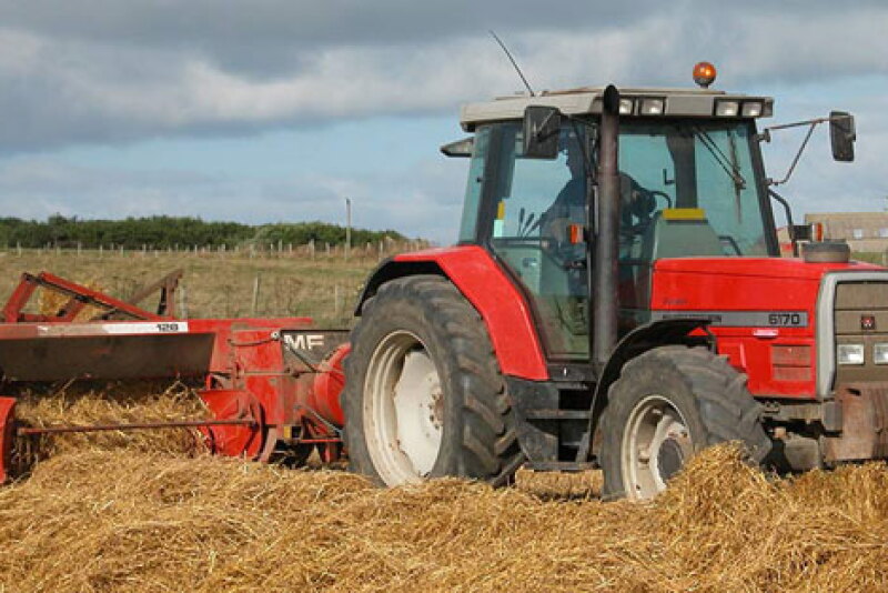 Red tractor at work in the field.