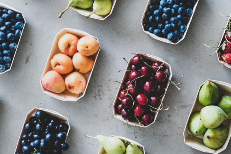 Cherries, blueberries, figs and other fruit separated in containers