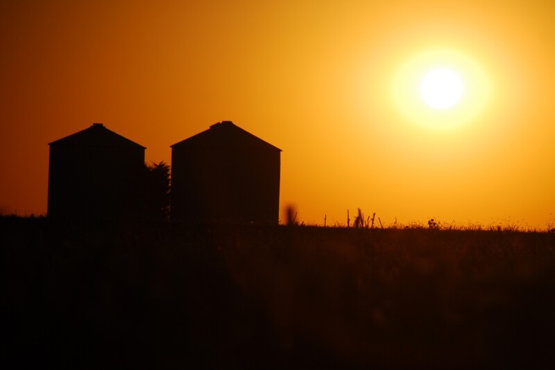 grain bins at sunset
