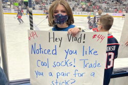 Jacey Snyder holding sign at Blue Jackets hockey game