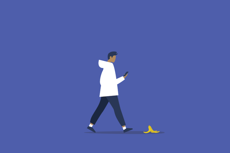 guy on cell phone about to fall from banana peel