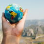 Globe in outstretched hand by Canva