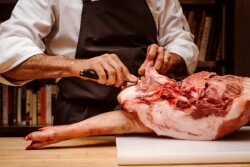 Adam Kaye, vice president of culinary affairs, butchers a Berkshire pork leg at the Blue Hill restaurant.